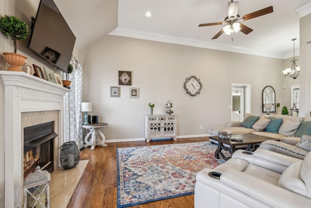 living area featuring a fireplace, crown molding, wood finished floors, baseboards, and ceiling fan with notable chandelier