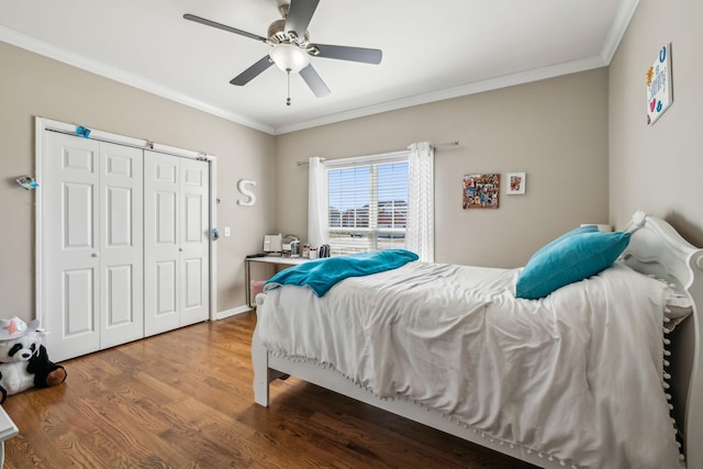 bedroom with a closet, a ceiling fan, crown molding, and wood finished floors