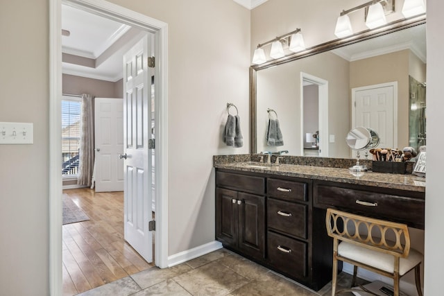 bathroom featuring ornamental molding, wood finished floors, vanity, and baseboards