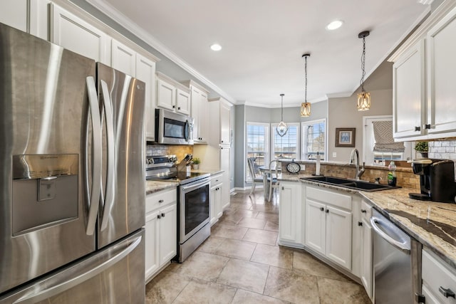 kitchen featuring ornamental molding, appliances with stainless steel finishes, a sink, and white cabinetry