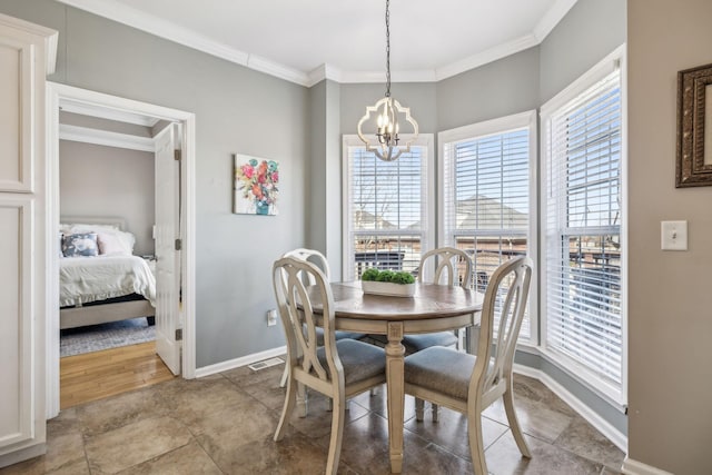 dining room featuring baseboards, ornamental molding, visible vents, and an inviting chandelier