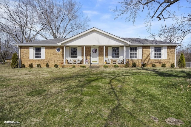 ranch-style home with a porch, a front yard, and brick siding