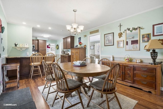 dining space featuring recessed lighting, a chandelier, crown molding, and wood finished floors