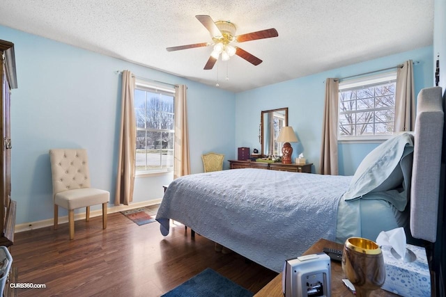 bedroom featuring a ceiling fan, a textured ceiling, baseboards, and wood finished floors