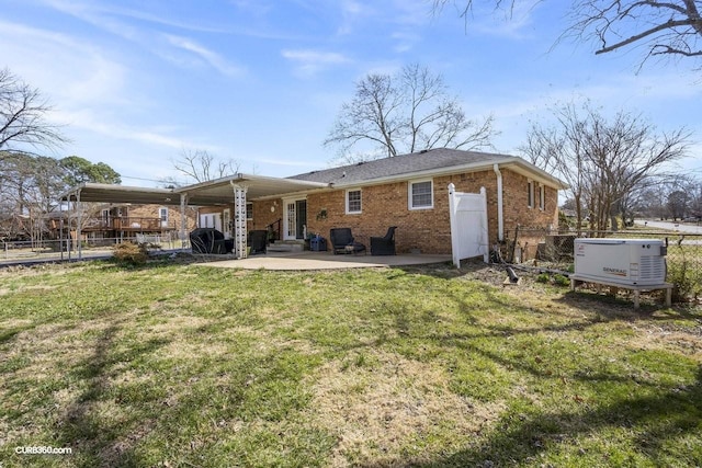 back of house with brick siding, a yard, fence, and a patio