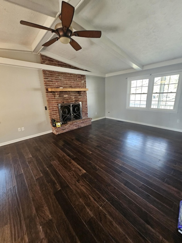 unfurnished living room featuring baseboards, lofted ceiling with beams, wood finished floors, a textured ceiling, and a brick fireplace