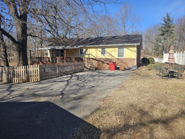 view of front of home featuring brick siding and fence