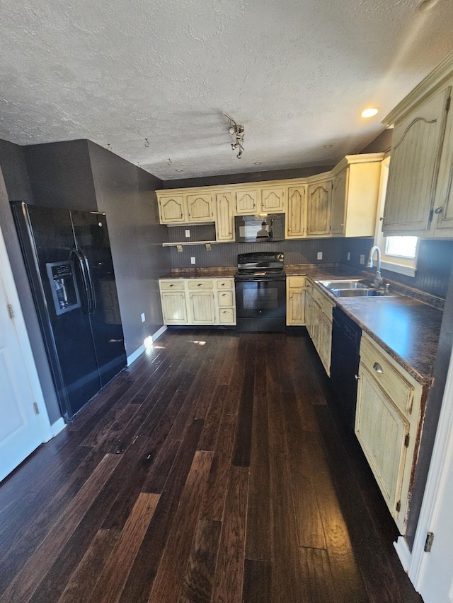 kitchen with a textured ceiling, black appliances, dark wood-style flooring, and a sink