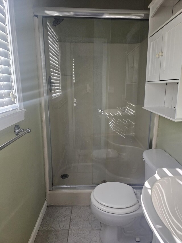 full bathroom featuring baseboards, a sink, a shower stall, and toilet