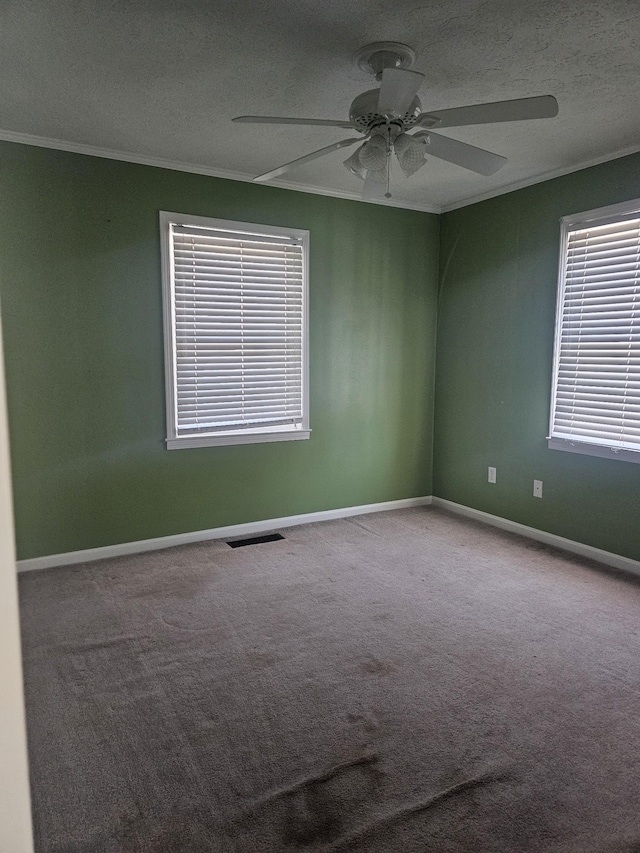 carpeted empty room with ornamental molding, a textured ceiling, baseboards, and a ceiling fan