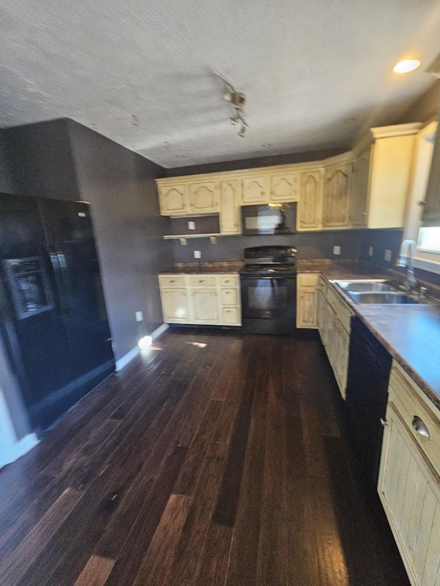 kitchen with dark wood finished floors, a sink, a textured ceiling, and black appliances