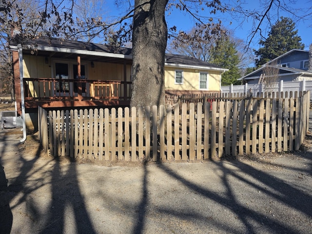 rear view of house featuring fence and a deck