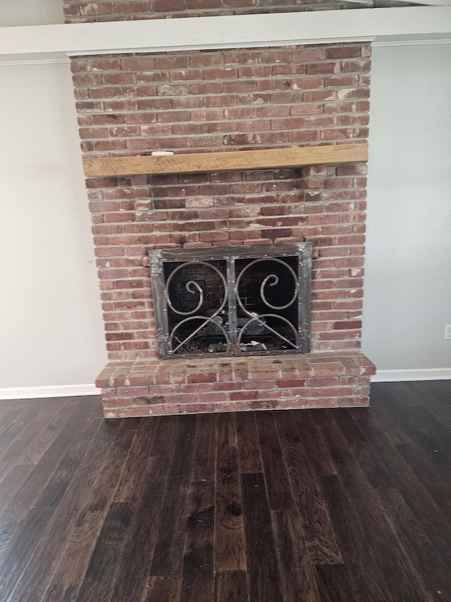 interior details featuring a fireplace, wood finished floors, and baseboards