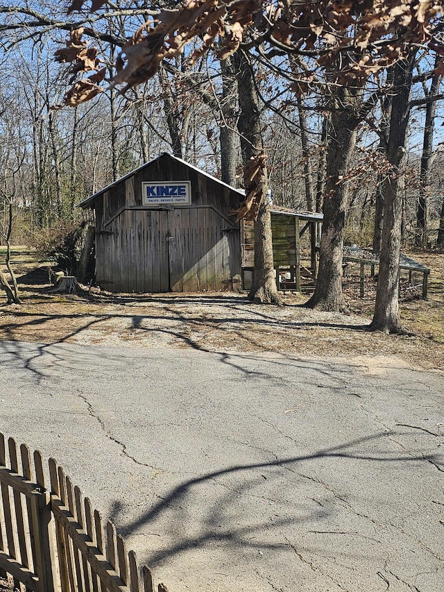 view of outbuilding with fence and an outdoor structure