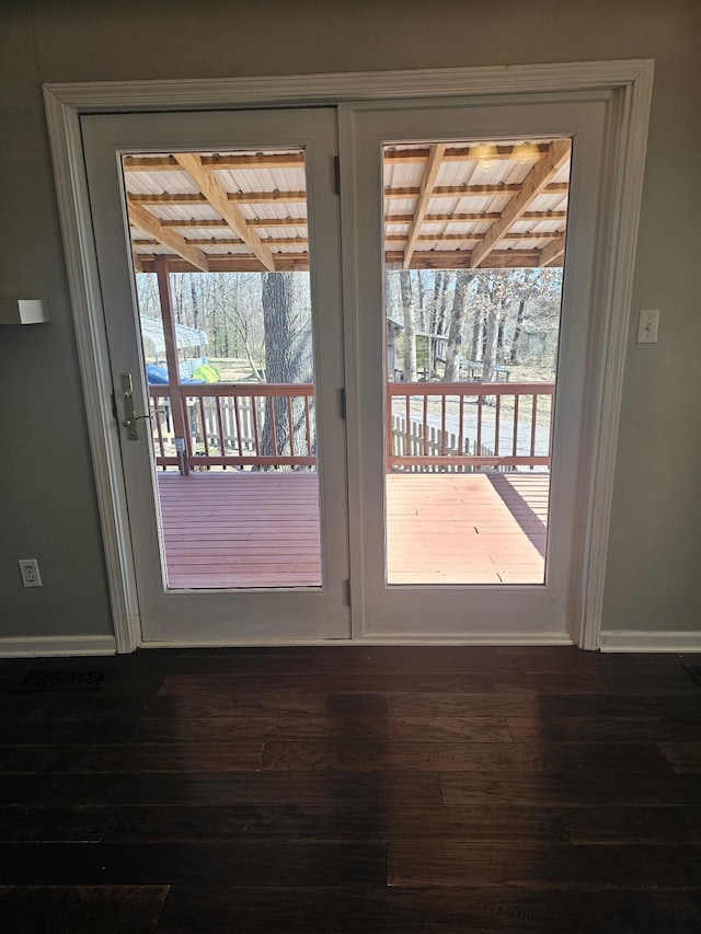 doorway featuring plenty of natural light, baseboards, and wood finished floors