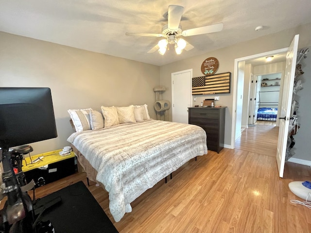 bedroom with light wood-type flooring, baseboards, and a ceiling fan