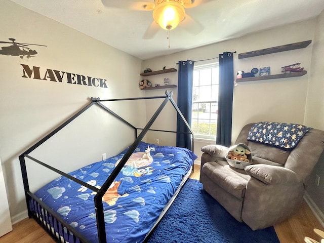 bedroom with ceiling fan, baseboards, and wood finished floors