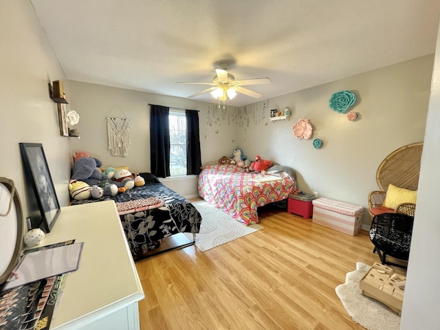 bedroom with a ceiling fan, light wood-style flooring, and baseboards