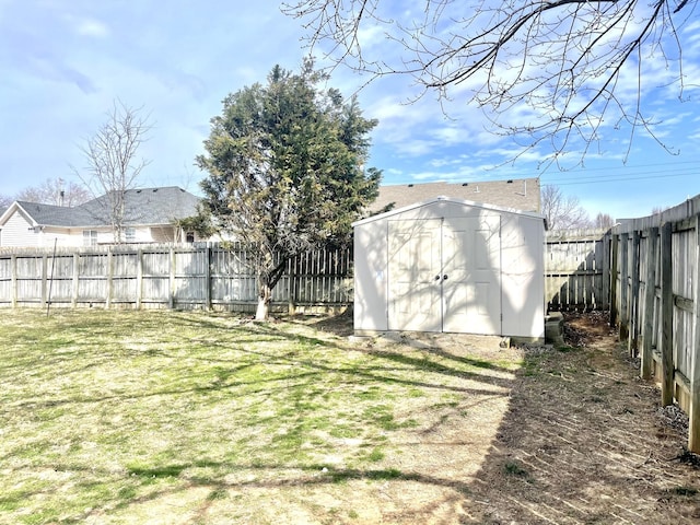 view of yard featuring a fenced backyard, a storage unit, and an outbuilding