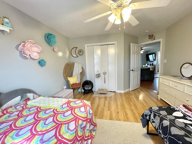 bedroom with a closet, light wood-type flooring, a ceiling fan, and baseboards