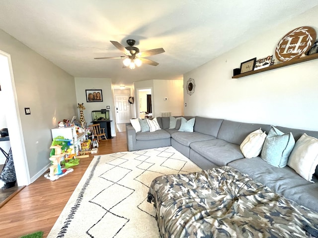 living area with ceiling fan, baseboards, and wood finished floors