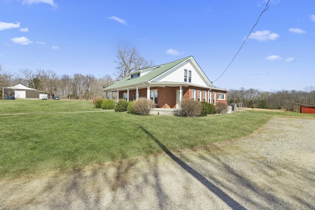view of side of home with a garage, brick siding, and a yard