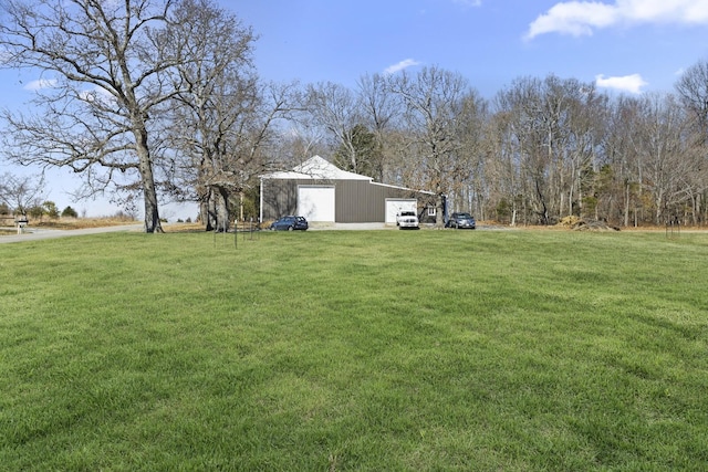 view of yard featuring a garage and an outbuilding