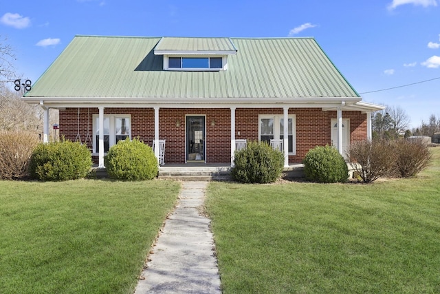 view of front of property featuring covered porch, a front lawn, metal roof, and brick siding