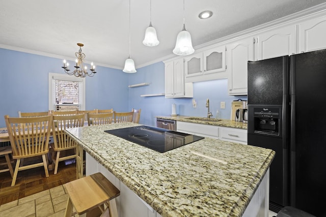 kitchen featuring ornamental molding, white cabinets, a sink, and black appliances
