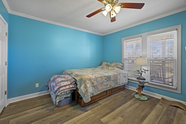 bedroom featuring crown molding, baseboards, ceiling fan, and wood finished floors