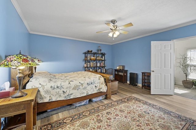 bedroom with ornamental molding, ceiling fan, baseboards, and wood finished floors