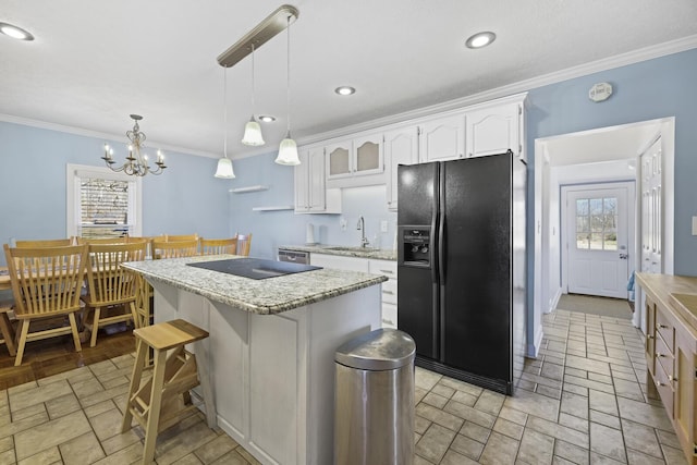 kitchen with crown molding, white cabinets, a kitchen island, a sink, and black appliances