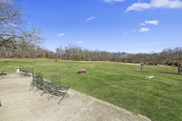 surrounding community with a patio area, a lawn, and a rural view