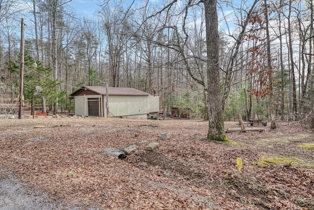 view of yard featuring a garage and an outbuilding