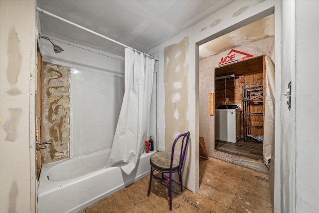 bathroom with washer / dryer and shower / bathtub combination with curtain