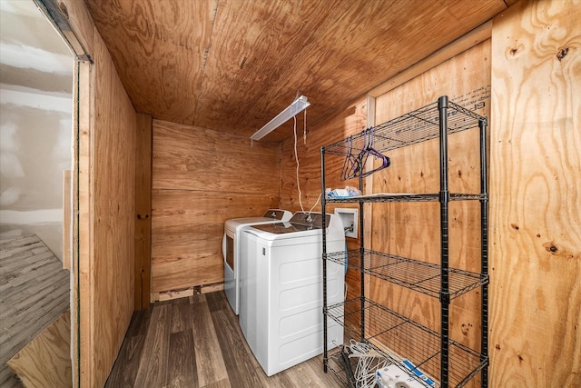 laundry area with laundry area, wooden walls, wood ceiling, wood finished floors, and washing machine and dryer