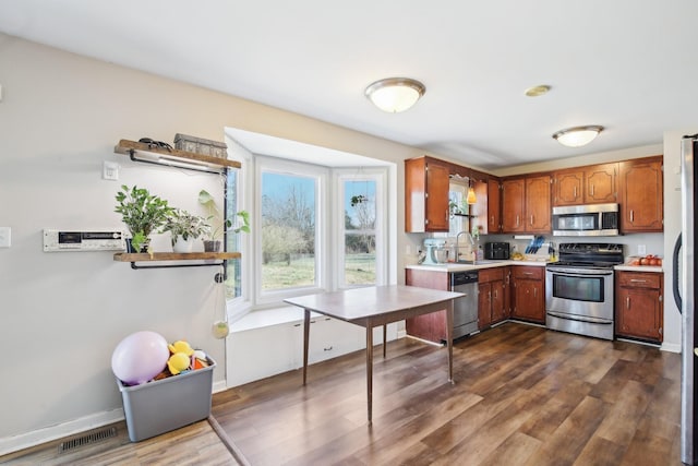 kitchen featuring dark wood-style flooring, light countertops, visible vents, appliances with stainless steel finishes, and a sink