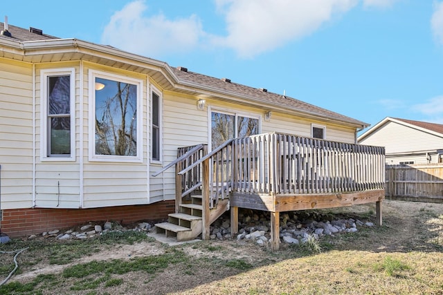 rear view of property with fence and a wooden deck