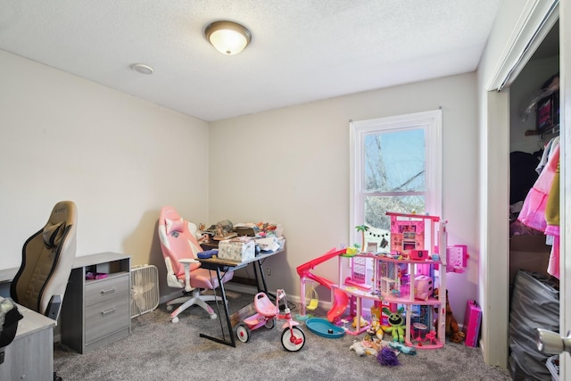 recreation room featuring carpet flooring and a textured ceiling