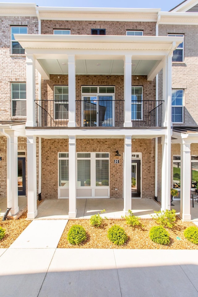 exterior space with brick siding and a balcony