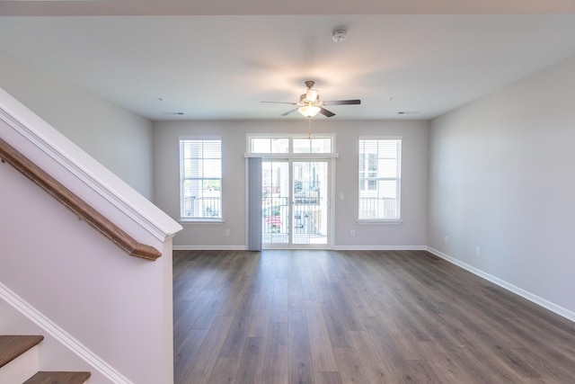 interior space featuring dark wood-type flooring, ceiling fan, stairway, and baseboards