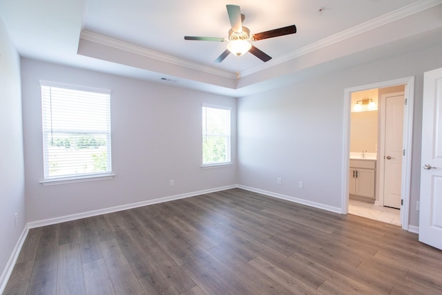 unfurnished bedroom featuring wood finished floors, a raised ceiling, visible vents, and baseboards