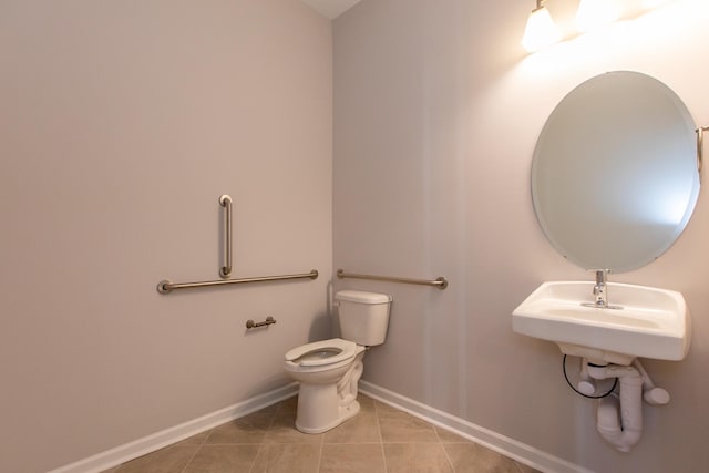 half bath featuring baseboards, toilet, and tile patterned floors