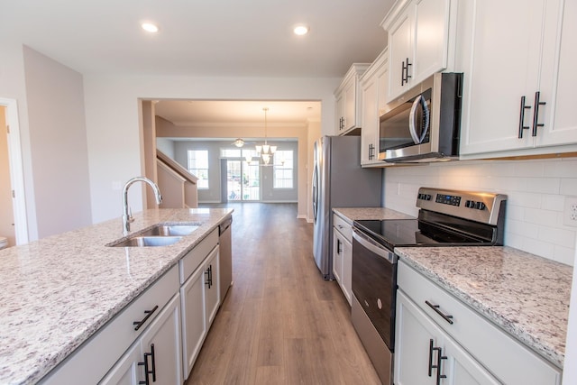 kitchen with light wood-style flooring, recessed lighting, a sink, appliances with stainless steel finishes, and tasteful backsplash