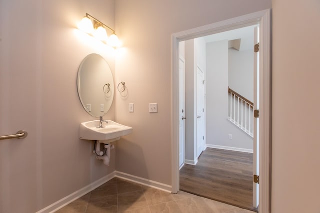 bathroom with tile patterned flooring, baseboards, and a sink