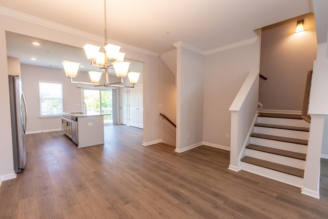 kitchen featuring stainless steel appliances, dark wood-style flooring, a sink, baseboards, and ornamental molding