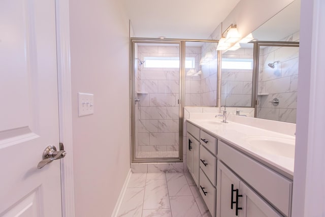 bathroom with a wealth of natural light, marble finish floor, a shower stall, and double vanity