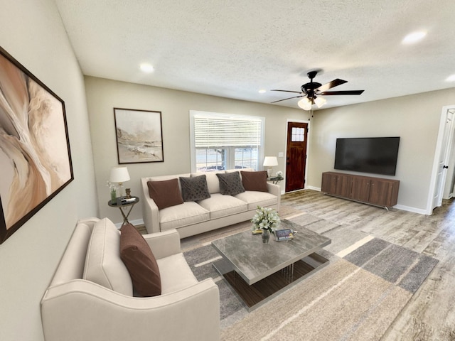 living area with baseboards, a ceiling fan, wood finished floors, a textured ceiling, and recessed lighting