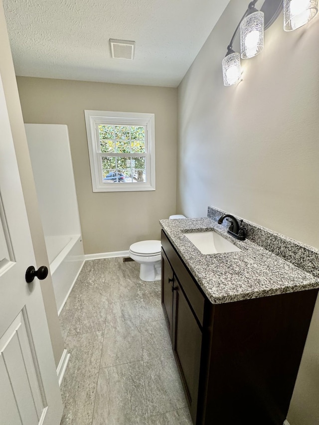 bathroom with a bathtub, visible vents, toilet, vanity, and baseboards