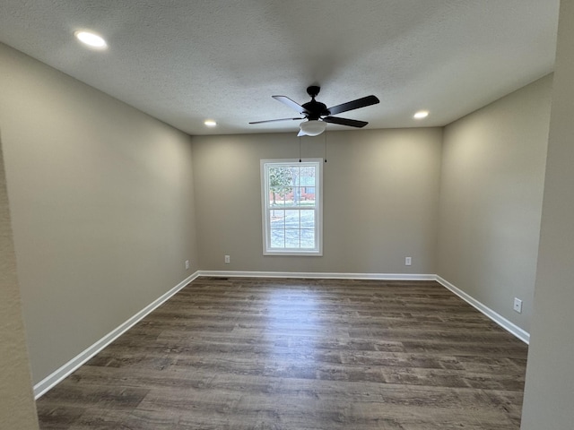 empty room with dark wood-type flooring, ceiling fan, a textured ceiling, and baseboards